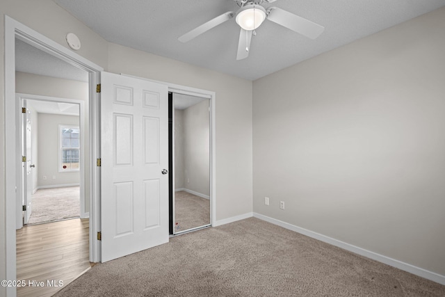 unfurnished bedroom featuring a closet, carpet flooring, a ceiling fan, and baseboards