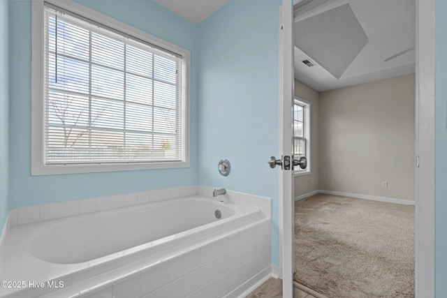 bathroom featuring a garden tub and baseboards