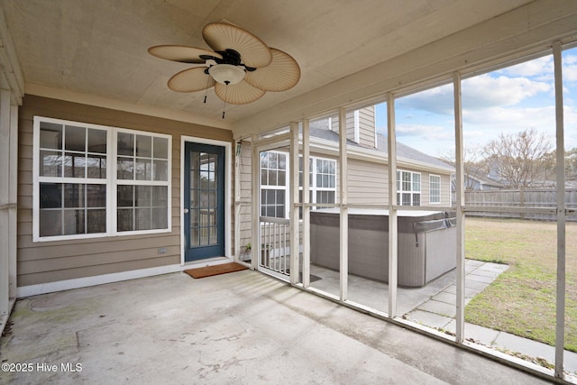 unfurnished sunroom with ceiling fan