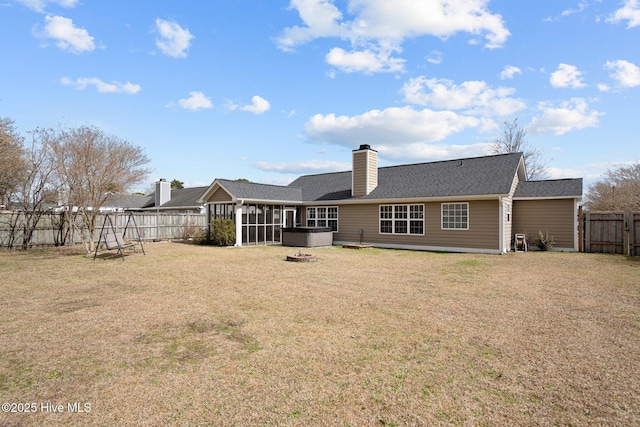 back of property featuring a sunroom, a fenced backyard, a lawn, and a chimney