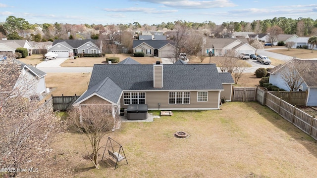 exterior space featuring a fire pit, a fenced backyard, a residential view, a chimney, and a yard