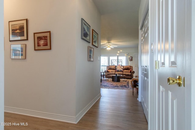 corridor featuring wood finished floors and baseboards