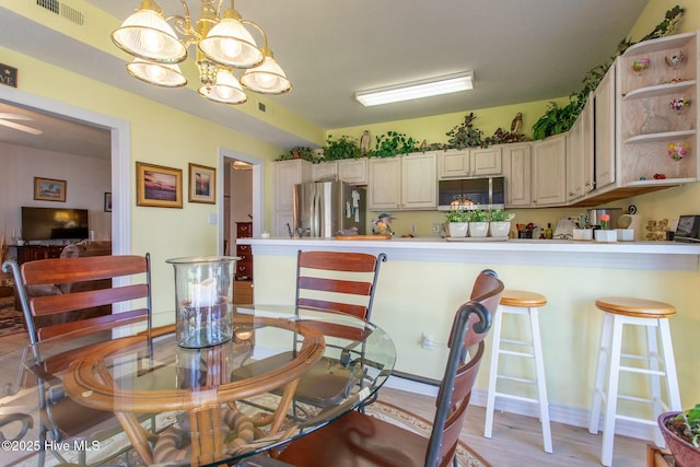 dining space with a notable chandelier, visible vents, and light wood-style floors