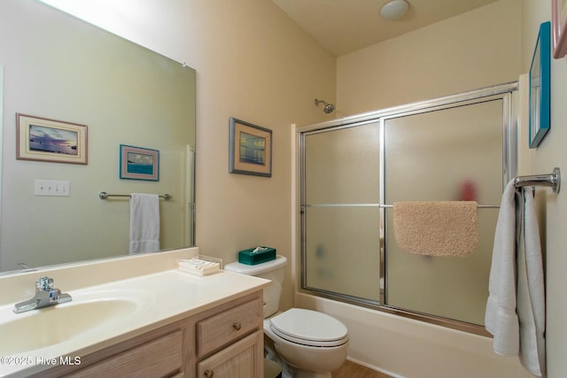 bathroom featuring vanity, toilet, and bath / shower combo with glass door