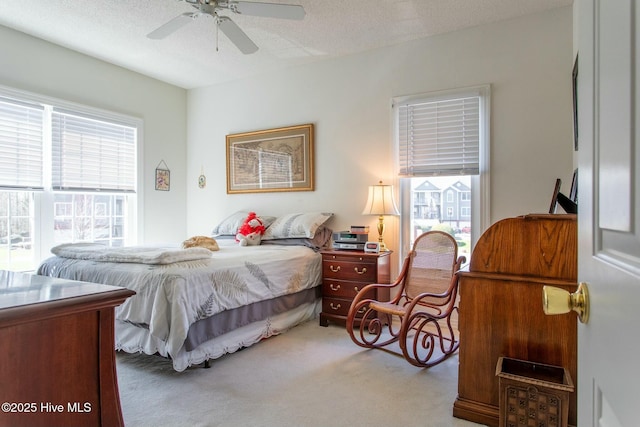 carpeted bedroom with a textured ceiling and a ceiling fan