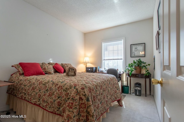 bedroom with a textured ceiling and light colored carpet