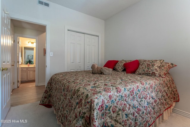 bedroom featuring baseboards, a closet, visible vents, and light colored carpet