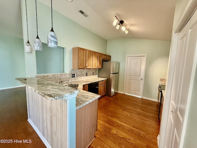 kitchen featuring visible vents, backsplash, freestanding refrigerator, a peninsula, and vaulted ceiling