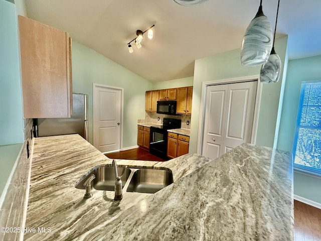 kitchen featuring brown cabinetry, baseboards, lofted ceiling, black appliances, and dark wood-type flooring