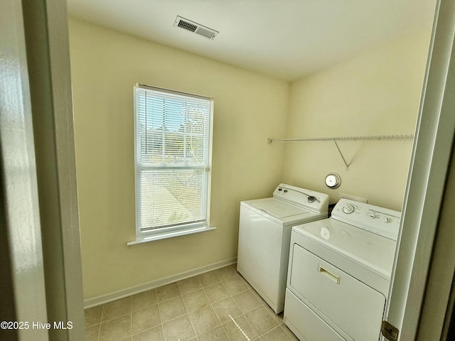 laundry room with visible vents, washing machine and dryer, light tile patterned floors, baseboards, and laundry area