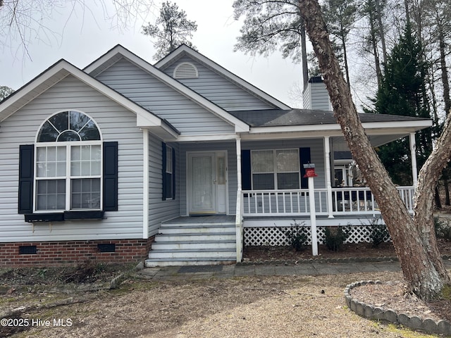 view of front of home with crawl space, covered porch, and a chimney