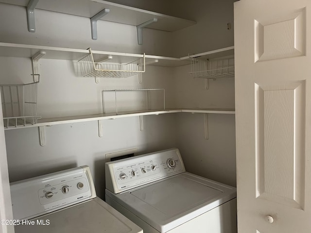 clothes washing area featuring laundry area and washer and clothes dryer