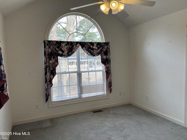 unfurnished room featuring lofted ceiling, visible vents, a ceiling fan, carpet flooring, and baseboards