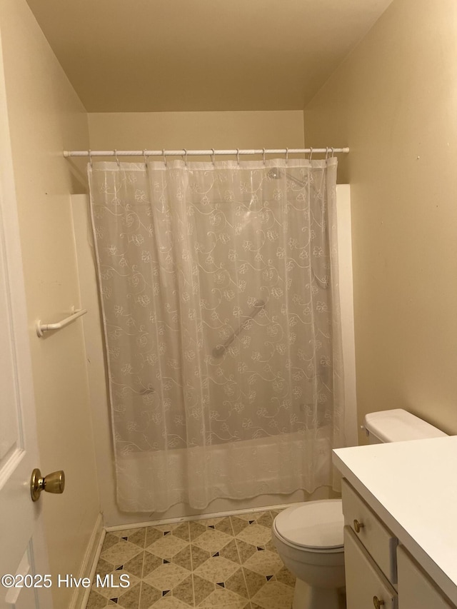 bathroom featuring vanity, shower / bath combo with shower curtain, and toilet