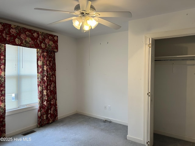 unfurnished bedroom with multiple windows, carpet flooring, visible vents, and baseboards