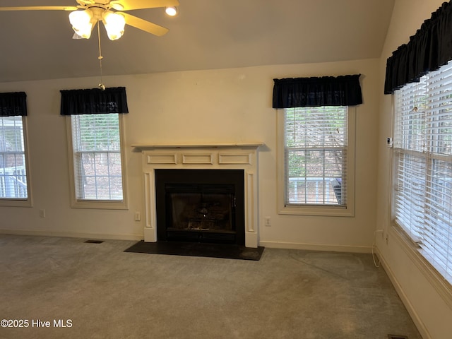 unfurnished living room with lofted ceiling, a wealth of natural light, a fireplace with flush hearth, and carpet flooring