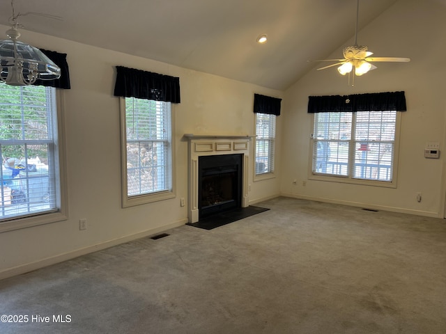 unfurnished living room with a fireplace with flush hearth, visible vents, vaulted ceiling, and carpet flooring