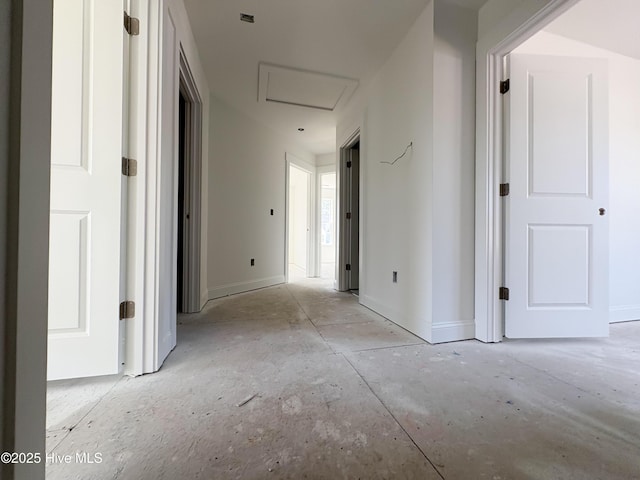 hall featuring baseboards and attic access