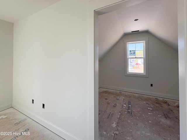 additional living space featuring vaulted ceiling and baseboards