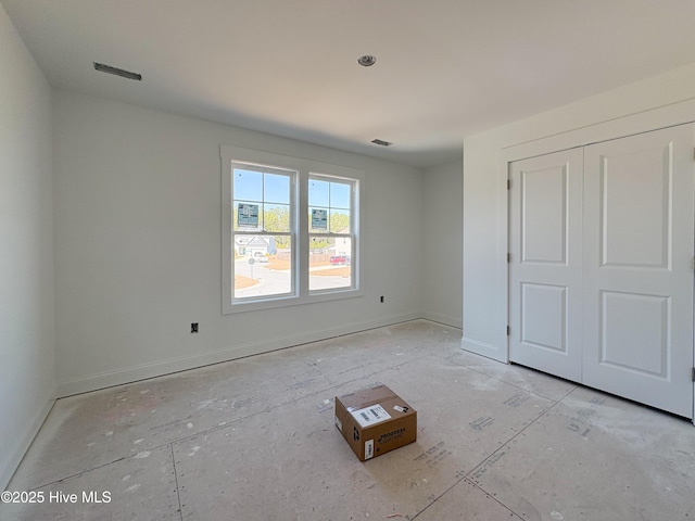 unfurnished bedroom with visible vents, baseboards, and a closet