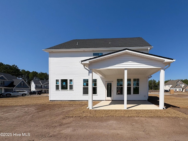 back of property featuring a patio area and a shingled roof