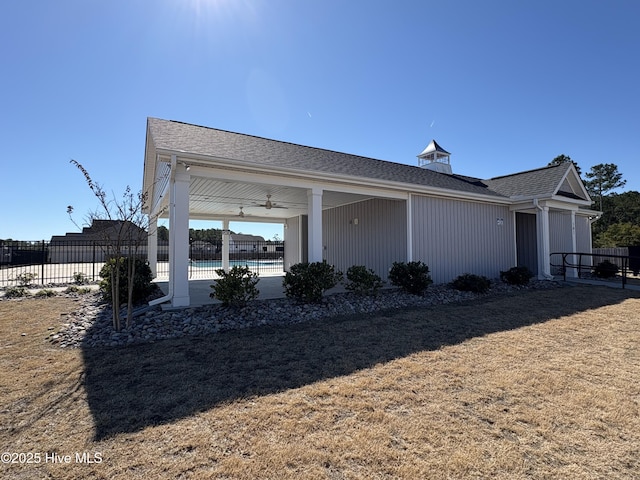 view of front facade featuring a fenced in pool, a ceiling fan, and fence