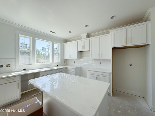 kitchen with decorative backsplash, baseboards, ornamental molding, and white cabinets