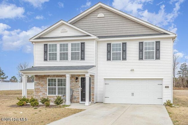 traditional-style house with an attached garage, concrete driveway, and stone siding