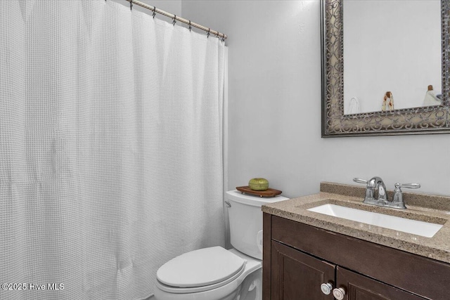 full bathroom featuring a shower with shower curtain, vanity, and toilet