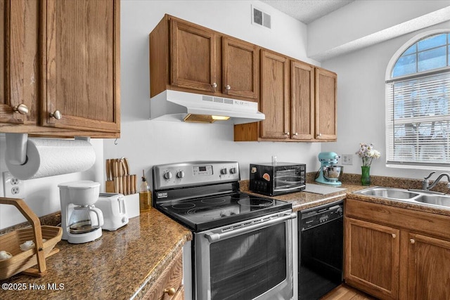 kitchen with visible vents, brown cabinetry, under cabinet range hood, black appliances, and a sink