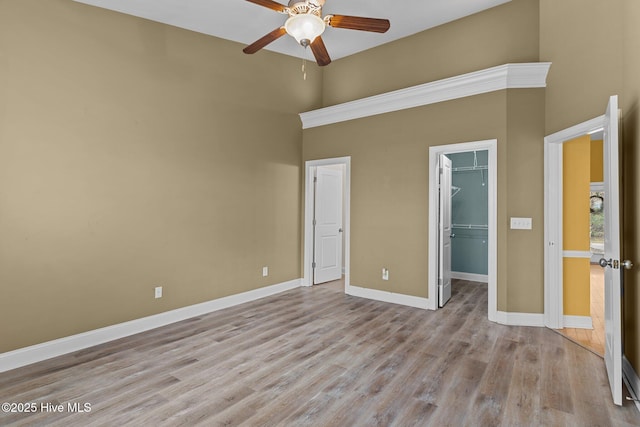 1036 Tideline Dr, Leland, NC 28451 - unfurnished bedroom with a towering ceiling, a walk in closet, wood finished floors, a closet, and ceiling fan