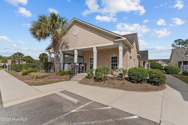 1036 Tideline Dr, Leland, NC 28451 - view of front of house featuring brick siding, a porch, and uncovered parking