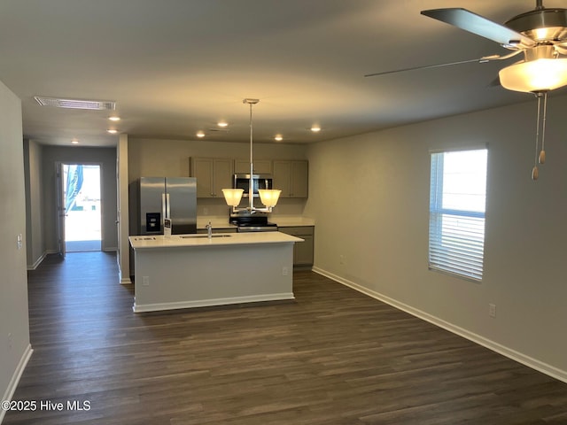 kitchen featuring dark wood finished floors, light countertops, appliances with stainless steel finishes, and a sink