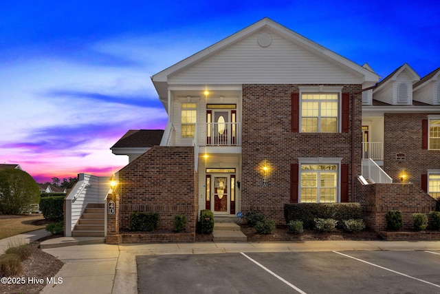 8855 Radcliff Dr NW Unit 4D, Calabash, NC 28467 - view of front of house featuring stairs, brick siding, a balcony, and uncovered parking