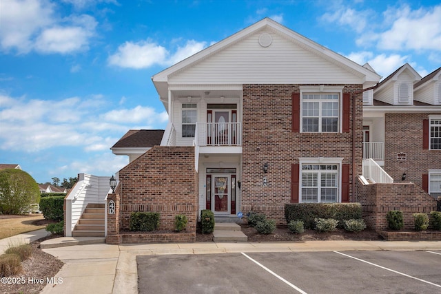 8855 Radcliff Dr NW Unit 4D, Calabash, NC 28467 - view of front facade with stairs, brick siding, uncovered parking, and a balcony