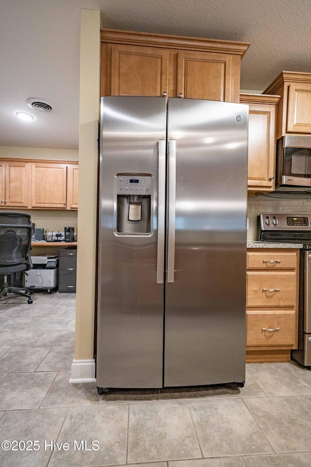 kitchen featuring light tile patterned floors, visible vents, appliances with stainless steel finishes, and backsplash