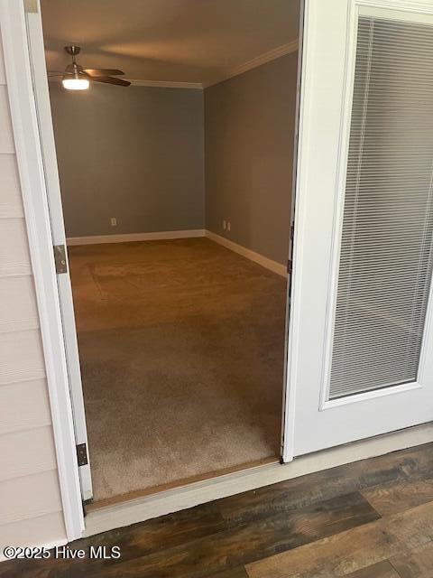 unfurnished room with crown molding, a ceiling fan, baseboards, and carpet floors