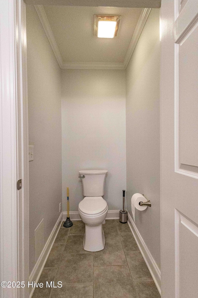 bathroom featuring ornamental molding, tile patterned flooring, toilet, and baseboards