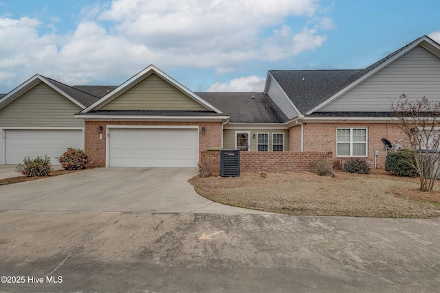 multi unit property with brick siding, a garage, and concrete driveway