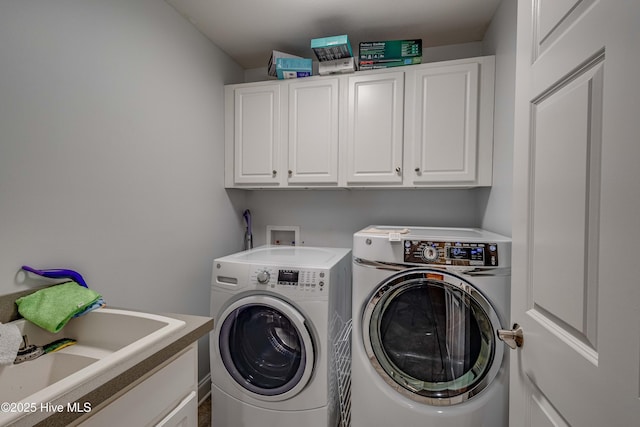 laundry area with cabinet space, a sink, and washer and clothes dryer