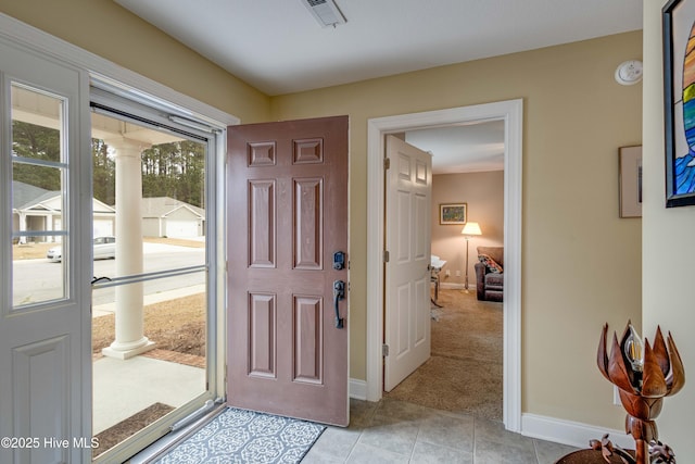 foyer entrance featuring ornate columns, baseboards, visible vents, and light tile patterned flooring