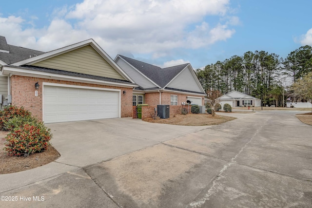 single story home featuring a garage, driveway, brick siding, and roof with shingles