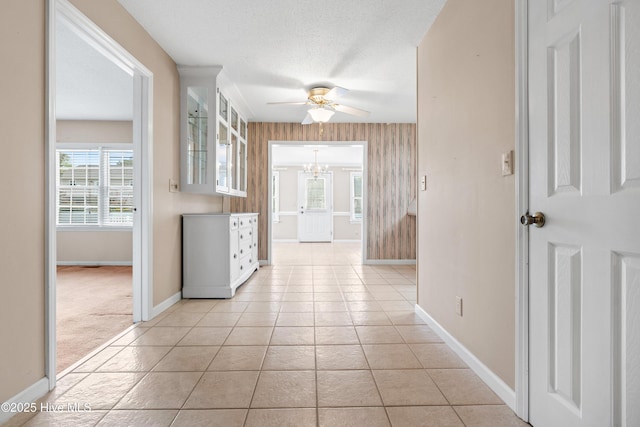 1611 Gores Landing Rd SW ., Unit Ocean Isle Beach, NC 28469 - hall featuring light colored carpet, a textured ceiling, light tile patterned floors, baseboards, and an inviting chandelier