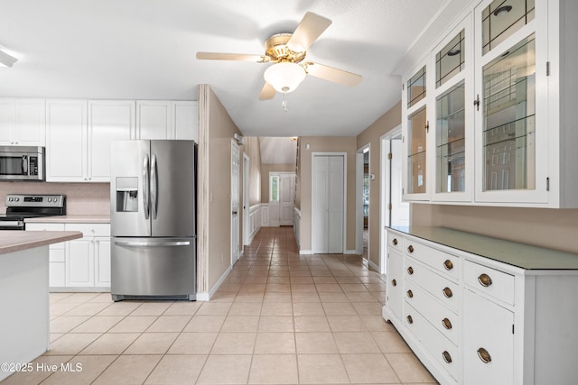 1611 Gores Landing Rd SW ., Unit Ocean Isle Beach, NC 28469 - kitchen with light tile patterned flooring, a ceiling fan, appliances with stainless steel finishes, glass insert cabinets, and white cabinets