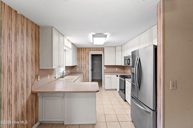 1611 Gores Landing Rd SW ., Unit Ocean Isle Beach, NC 28469 - kitchen featuring light countertops, a sink, white cabinetry, appliances with stainless steel finishes, and a peninsula