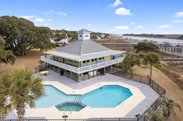 1611 Gores Landing Rd SW ., Unit Ocean Isle Beach, NC 28469 - view of swimming pool featuring fence, a pool with connected hot tub, a water view, and a patio