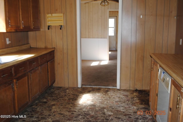 kitchen featuring wood walls and white dishwasher