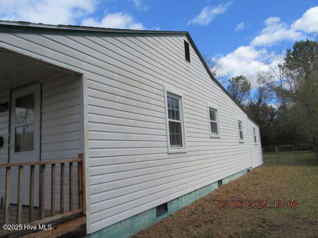 view of side of property featuring crawl space and fence