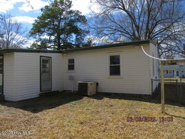 rear view of house featuring a yard and cooling unit