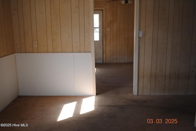 carpeted empty room with wooden walls